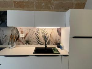 a kitchen with white cabinets and a counter top at Don Ninì in Sava