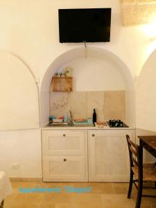 a kitchen with a tv on the wall at Ramasole in Ostuni