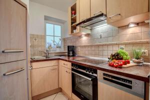 a kitchen with a sink and a stove top oven at "Landhaus Voss" Typ 3 Nr9 in Staberdorf