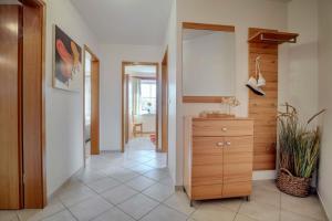 a hallway with a wooden dresser and a mirror at "Landhaus Voss" Typ 3 Nr9 in Staberdorf