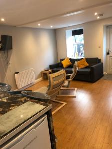 un soggiorno con divano nero e sedie di Contemporary Town Centre on the Wild Atlantic Way a Bantry