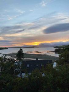 un tramonto su un corpo d'acqua con una casa di Contemporary Town Centre on the Wild Atlantic Way a Bantry