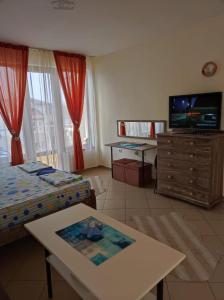 a living room with two beds and a television at Апартамент - студио в кв Сарафово с морски изглед in Burgas City