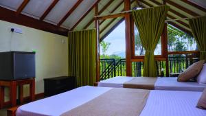 una camera con 2 letti, una TV e un balcone di Sigiri SAAT Cabana a Sigiriya