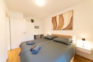 a bedroom with a large bed with blue pillows on it at Cozy garden apartment in Graz