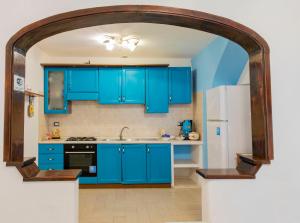 a kitchen with blue cabinets and a white refrigerator at MARE NOSTRUM - Beachfront House with Sea View - 2 Bedrooms - Sant'Angelo Ischia in Sant'Angelo D'Ischia +20 photos