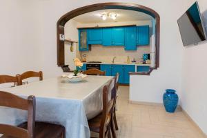 a kitchen and dining room with blue cabinets and a table at MARE NOSTRUM - Beachfront House with Sea View - 2 Bedrooms - Sant'Angelo Ischia in Sant'Angelo D'Ischia