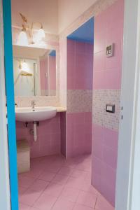 a pink bathroom with a sink and a mirror at MARE NOSTRUM - Beachfront House with Sea View - 2 Bedrooms - Sant'Angelo Ischia in Sant'Angelo D'Ischia