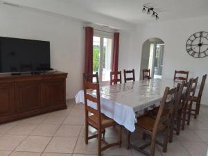 a dining room with a table and a television at Villa L'Audaline in Roquebrune-sur-Argens