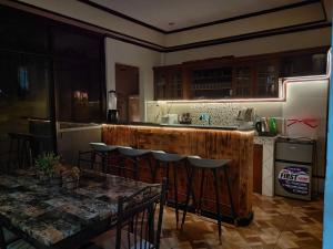 a kitchen with a wooden bar with chairs and a table at Spacious 3-Floor 6-BR Home, Pool, BBQ, KTV, WIFI in Davao City +27 photos