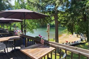 a picnic table with an umbrella next to a lake at Château Morritt in Mont-Tremblant