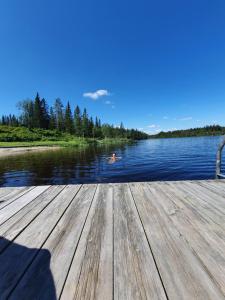 un uomo che nuota in acqua su un molo di Ål-hytte i Snertingdal på solrik tomt med suveren beliggenhet a Gjøvik