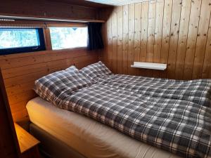 un letto in una camera con pareti rivestite in legno di Ål-hytte i Snertingdal på solrik tomt med suveren beliggenhet a Gjøvik