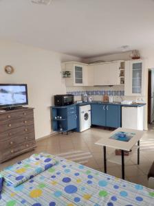 a kitchen with blue cabinets and a table in a room at Апартамент - студио в кв Сарафово с морски изглед in Burgas City