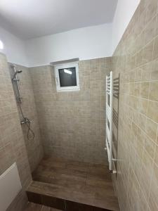 baño con ducha y ventana en la pared en Apartament CITY MALL, en Constanţa