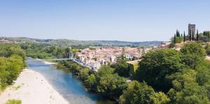 a bridge over a river in a town at camping la plage de l'orb in Cessenon