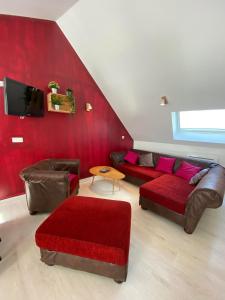 a living room with a couch and a red wall at Gîte 3 chambres à Villandry in Villandry
