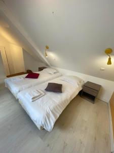 two beds in a room with white sheets at Gîte 3 chambres à Villandry in Villandry