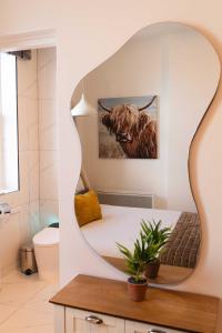 a bathroom with a mirror with a cow on the wall at Croke park apartment in Dublin
