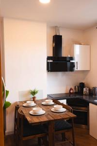 a kitchen with a wooden table with four chairs at Croke park apartment in Dublin +10 photos