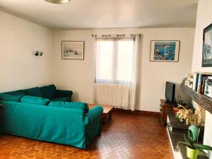 a living room with a blue couch and a window at Spacieux appartement proche centre et piscine in Condom