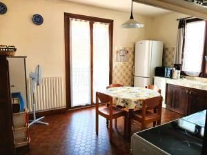 a kitchen with a table and chairs and a refrigerator at Spacieux appartement proche centre et piscine in Condom +21 photos