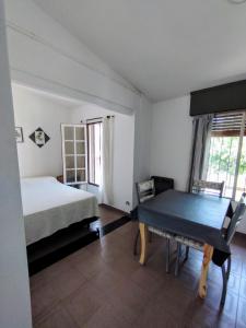 ein Schlafzimmer mit einem Bett und einem Tisch darin in der Unterkunft El Departamento de Oscar in Villa María