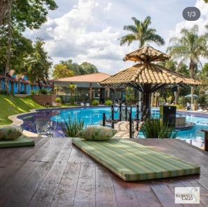 a table with an umbrella next to a swimming pool at Hotel fazenda Floresta do Lago in Socorro
