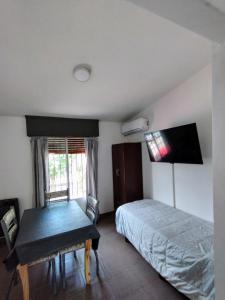 ein Schlafzimmer mit einem Bett, einem Tisch und einem Schreibtisch in der Unterkunft El Departamento de Oscar in Villa María