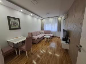 a living room with a couch and a table at Nela Bl in Banja Luka +4 photos
