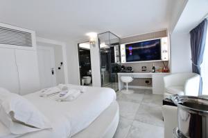 a white bedroom with a white bed and a bathroom at Domus De Cinti in Tivoli