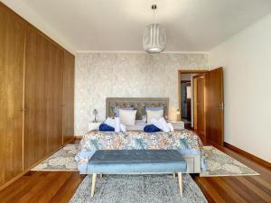 een slaapkamer met een groot bed en een blauwe bank bij Zen House By The Madeira Luxury Collection in Arco da Calheta +20 foto's