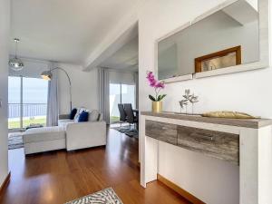 een woonkamer met een bank en een tafel met een spiegel bij Zen House By The Madeira Luxury Collection in Arco da Calheta