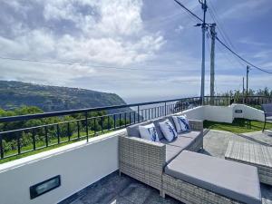 een balkon met een bank en uitzicht op de oceaan bij Zen House By The Madeira Luxury Collection in Arco da Calheta