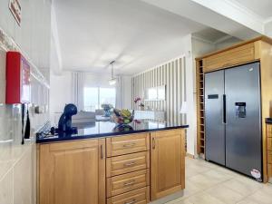 een keuken met houten kasten en een roestvrijstalen koelkast bij Zen House By The Madeira Luxury Collection in Arco da Calheta