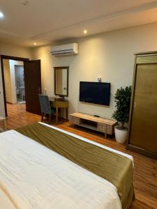 a bedroom with a large bed and a flat screen tv at درة رواق in Riyadh