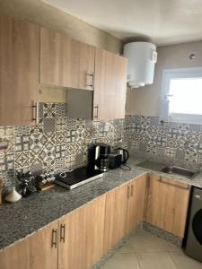 een keuken met houten kasten en een aanrechtblad bij Darkoum Apartment Anza in Agadir