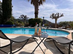 a table with bottles and glasses on it next to a swimming pool at Le Château d'Argens in Les Arcs sur Argens