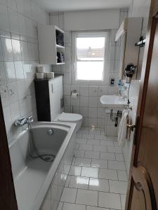 een badkamer met een bad, een toilet en een wastafel bij Casa Ilona in Düren - Eifel