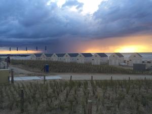 a group of beach huts on the beach at sunset at Beach Hotel Katwijk in Katwijk