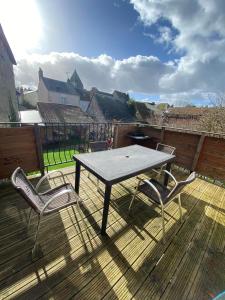 a picnic table and two chairs on a deck at Appt 5 personnes - 2 Chambres, terrasse et jardin in Villandry +2 photos
