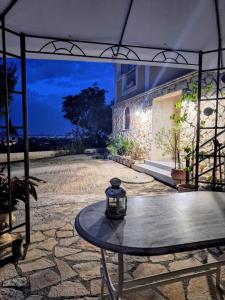 a table with a lantern sitting on top of a patio at Meltemaki in Mouzákion