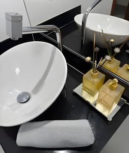 ein Badezimmer mit Waschbecken und Spiegel in der Unterkunft Conforto e Praticidade em Araxá in Araxá