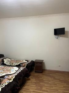 a room with two beds and a tv on the wall at Lenko in Goris