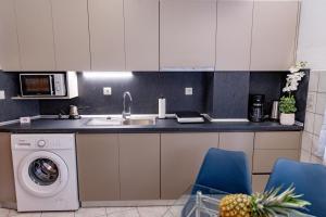 a kitchen with a sink and a washing machine at ANGO City Center in Stavros