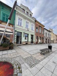 a bench in the middle of a street with buildings at Apartament Rynek 17 in Krosno
