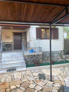 eine Terrasse mit einer Treppe und einer Steinmauer in der Unterkunft Dimis Right House in Sozopoli