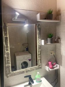 einen Badezimmerspiegel mit einem Waschbecken und einer Waschmaschine in der Unterkunft Dimis Right House in Sozopoli + 27 Fotos