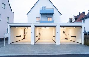 un gruppo di quattro porte del garage di fronte a una casa di AMBERG APART - Apartment-Wohnung 3 - Wohnraum auf Zeit ad Amberg
