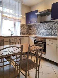 Una cocina con una mesa y sillas en una cocina. en Mozart27 - Ferienwohnung, en Pirmasens 4 fotos más